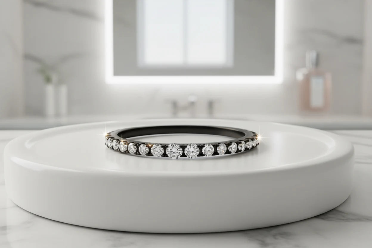 Black Midi Ring Set shown as a slim black band ring with sparkling clear stones, photographed on a white round display platform in a bright bathroom vanity setting with soft reflections and a clean, modern background | OriaJewel