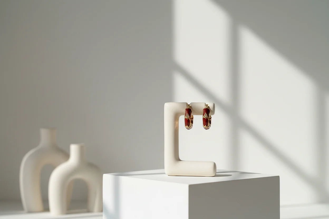 Burgundy Huggie Hoop Earrings on white stand with window shadows | OriaJewel