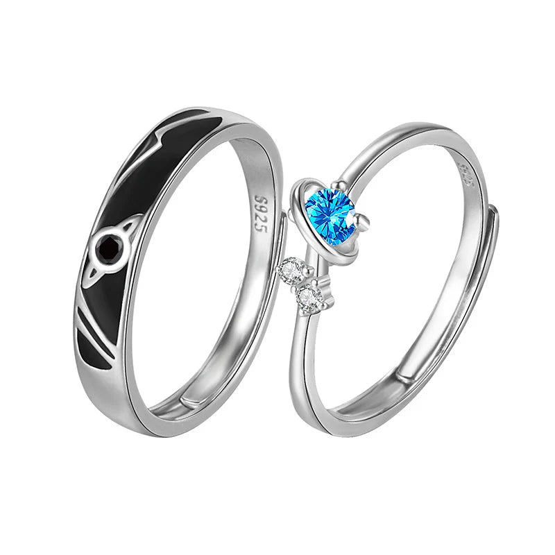 Cosmic Heart Couple Ring product image on a white background showing the full matching set, including the black enamel cosmic band ring and the blue heart gemstone ring with small clear stone accents | OriaJewel