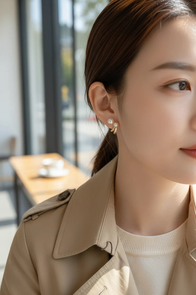 Double Pearl Huggie Hoop Earrings close-up on model with trench coat | OriaJewel
