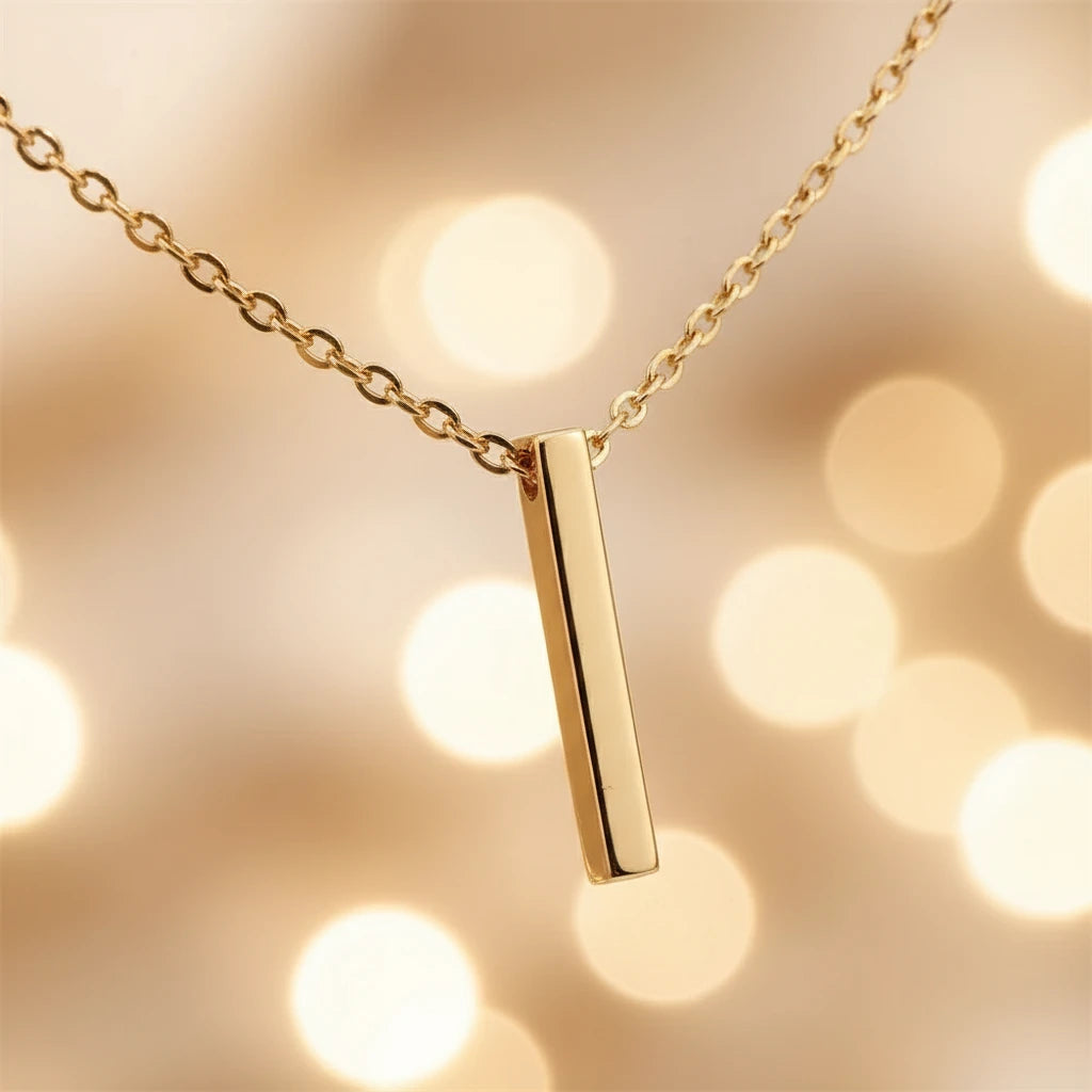 Drop Bar Pendant Necklace showing polished gold bar pendant close-up with soft glowing bokeh background | Oria Jewel