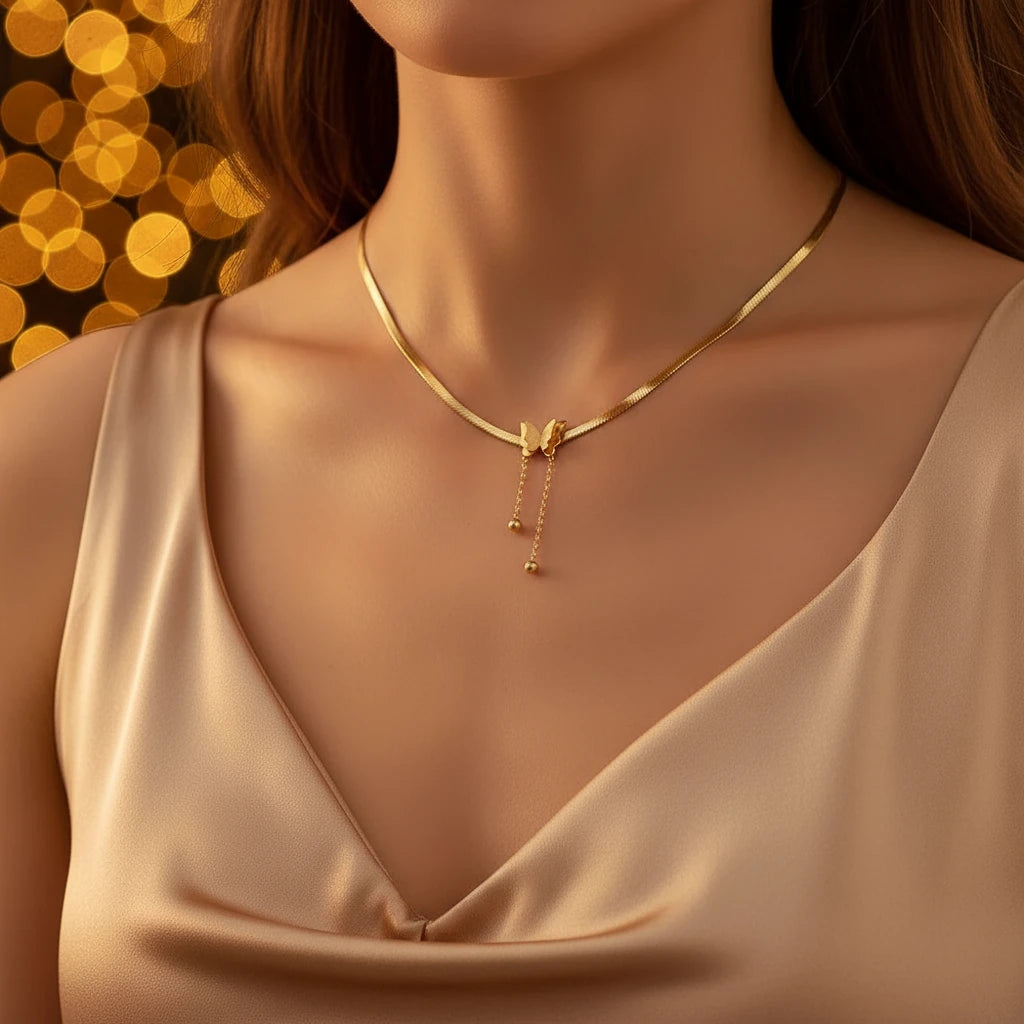 Gold Butterfly Chain Necklace with delicate pendant worn by woman in satin dress under golden lights | Oria Jewel
