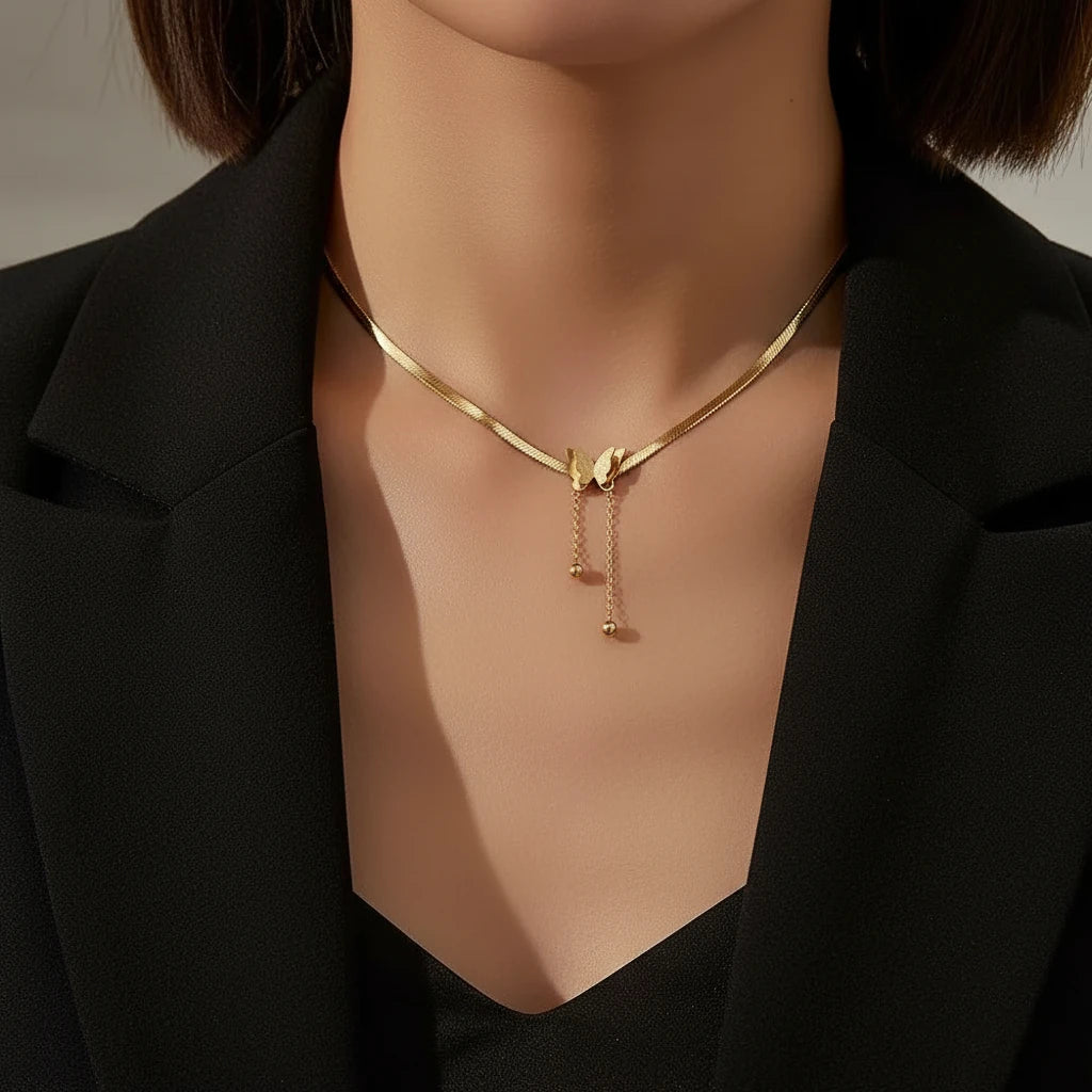 Gold Butterfly Chain Necklace adding a touch of charm to a chic black blazer outfit | Oria Jewel