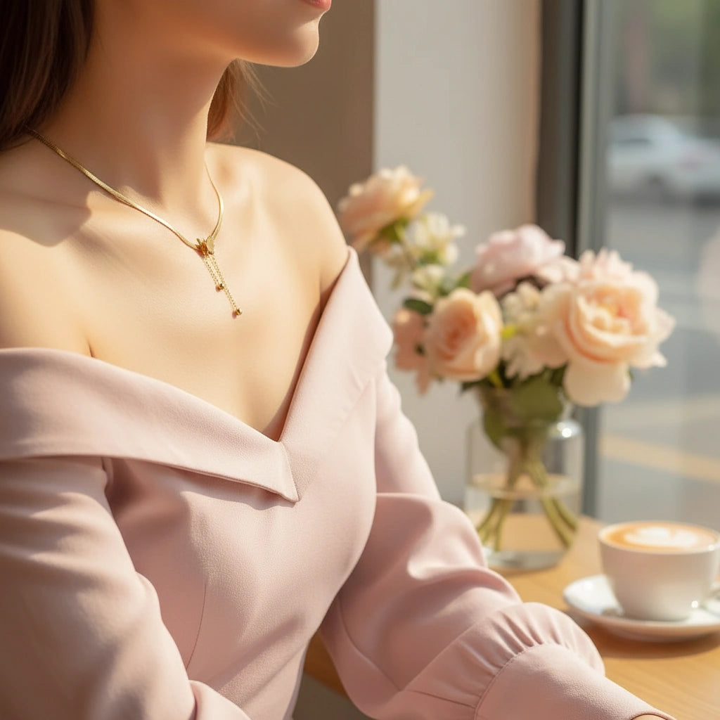 Gold Butterfly Chain Necklace worn with pink off-shoulder blouse at cozy café setting | Oria Jewel