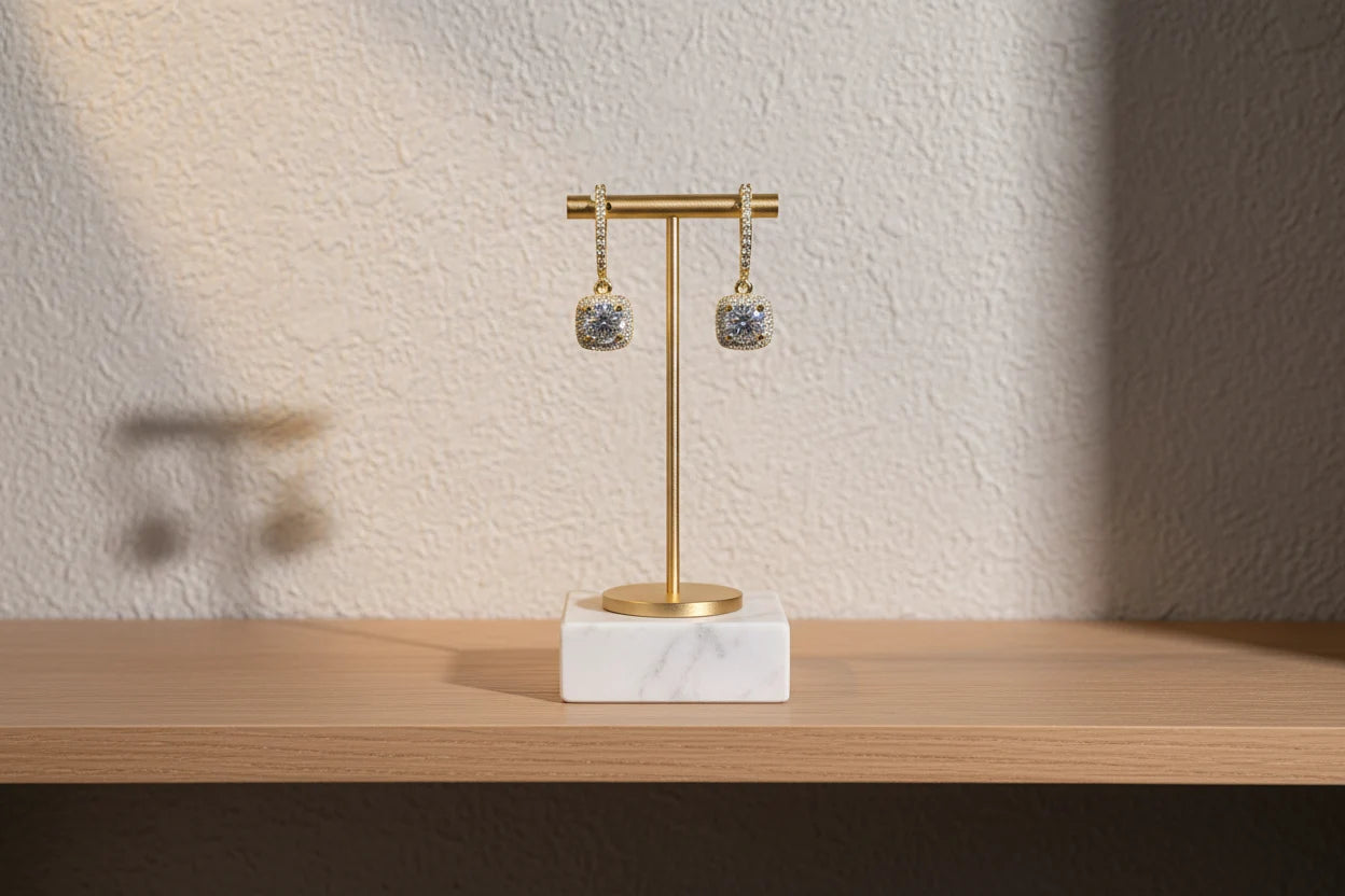Gold Crystal Drop Huggie Earrings on gold display stand with marble base on wood shelf | OriaJewel