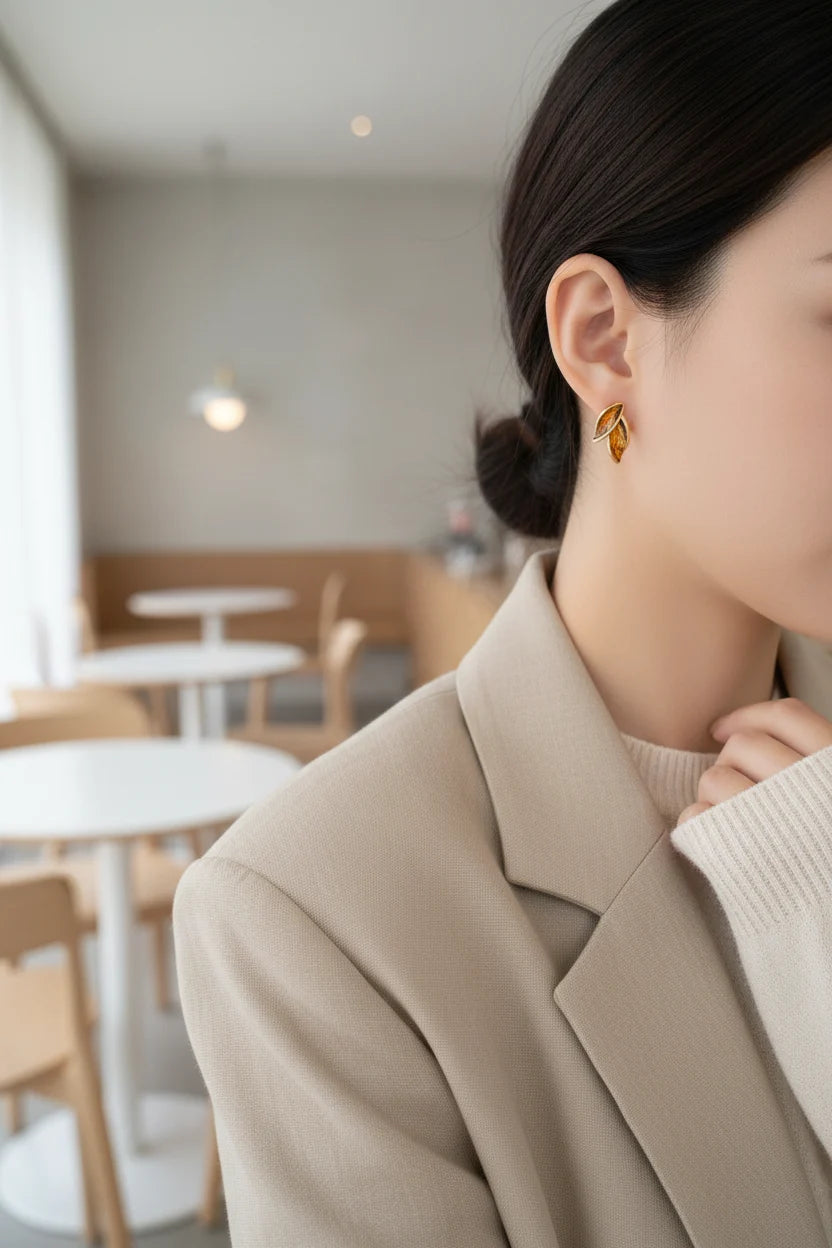 Gold Double Leaf Stud Earrings close-up on ear with beige blazer | OriaJewel