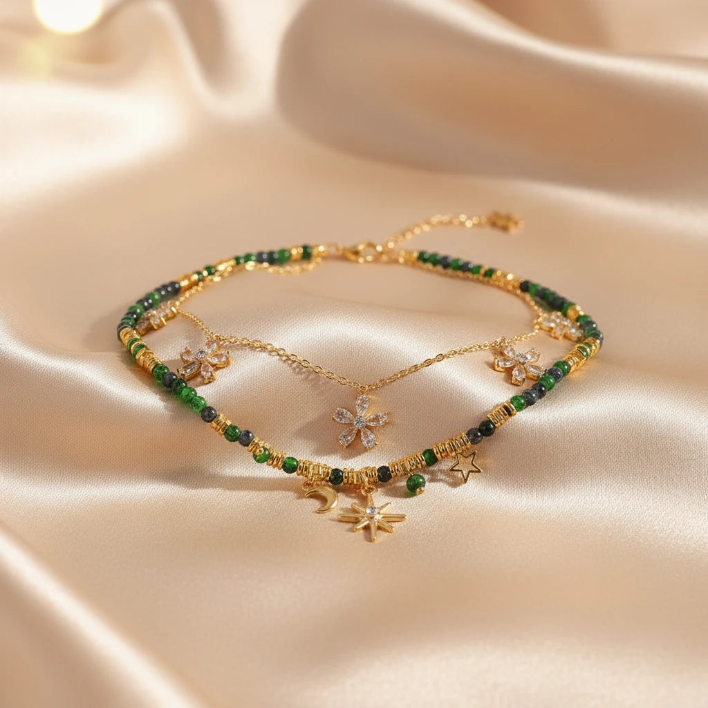 Gold Layered Star Necklace laid on soft satin fabric highlighting green beads, moon and star pendants | Oria Jewel