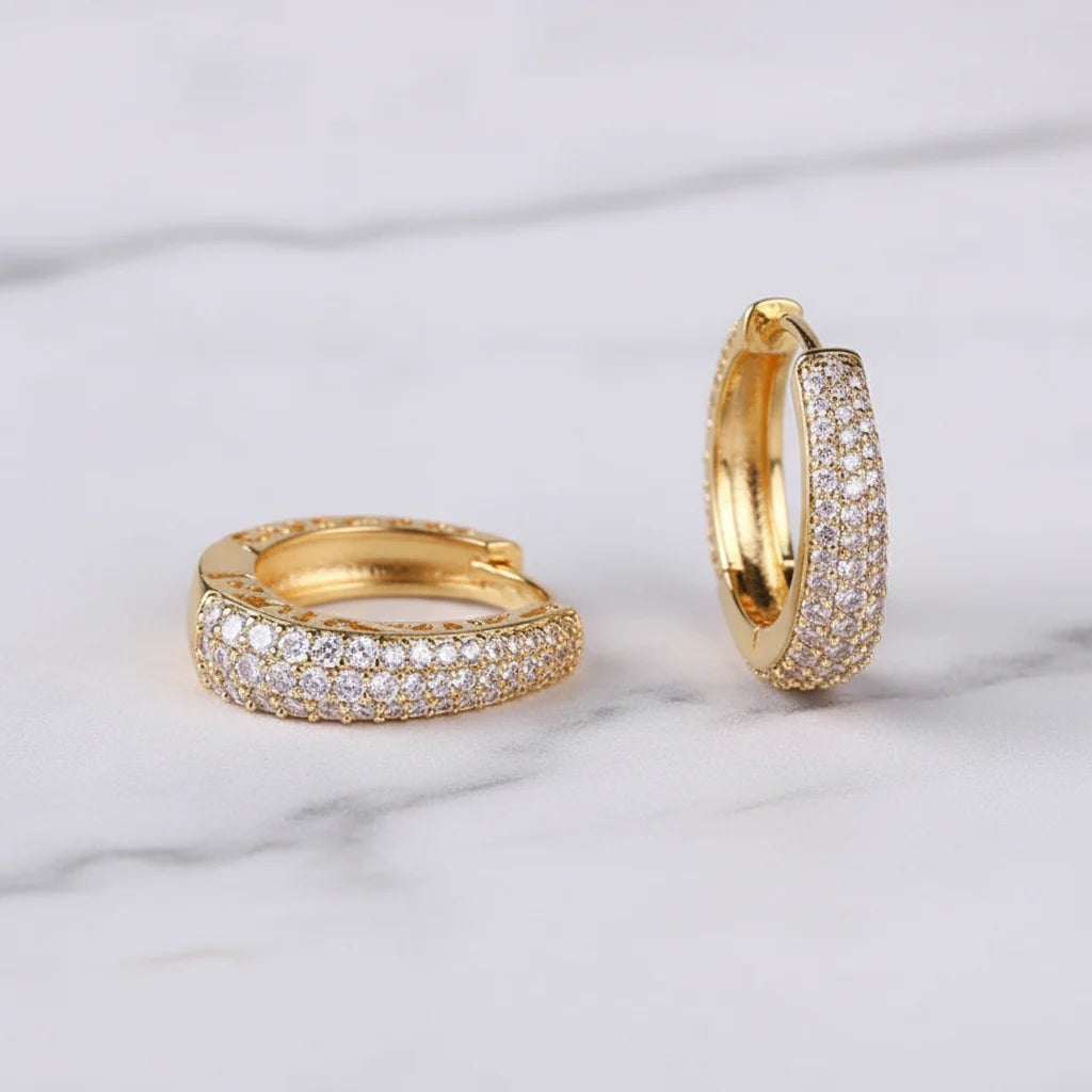 Gold Pavé Huggie Hoop Earrings close-up on marble surface | OriaJewel