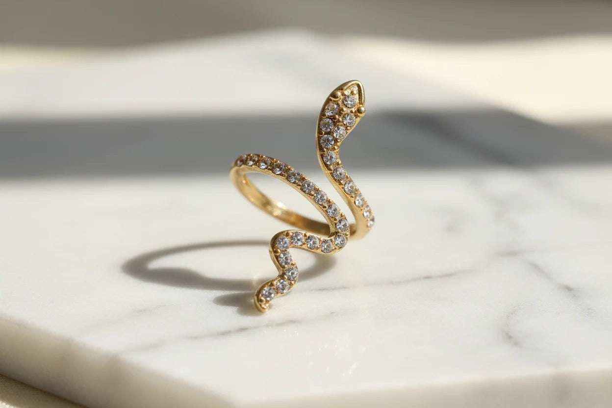 gold Pavé snake wrap ring close-up on white marble with soft sunlight and shadow | OriaJewel