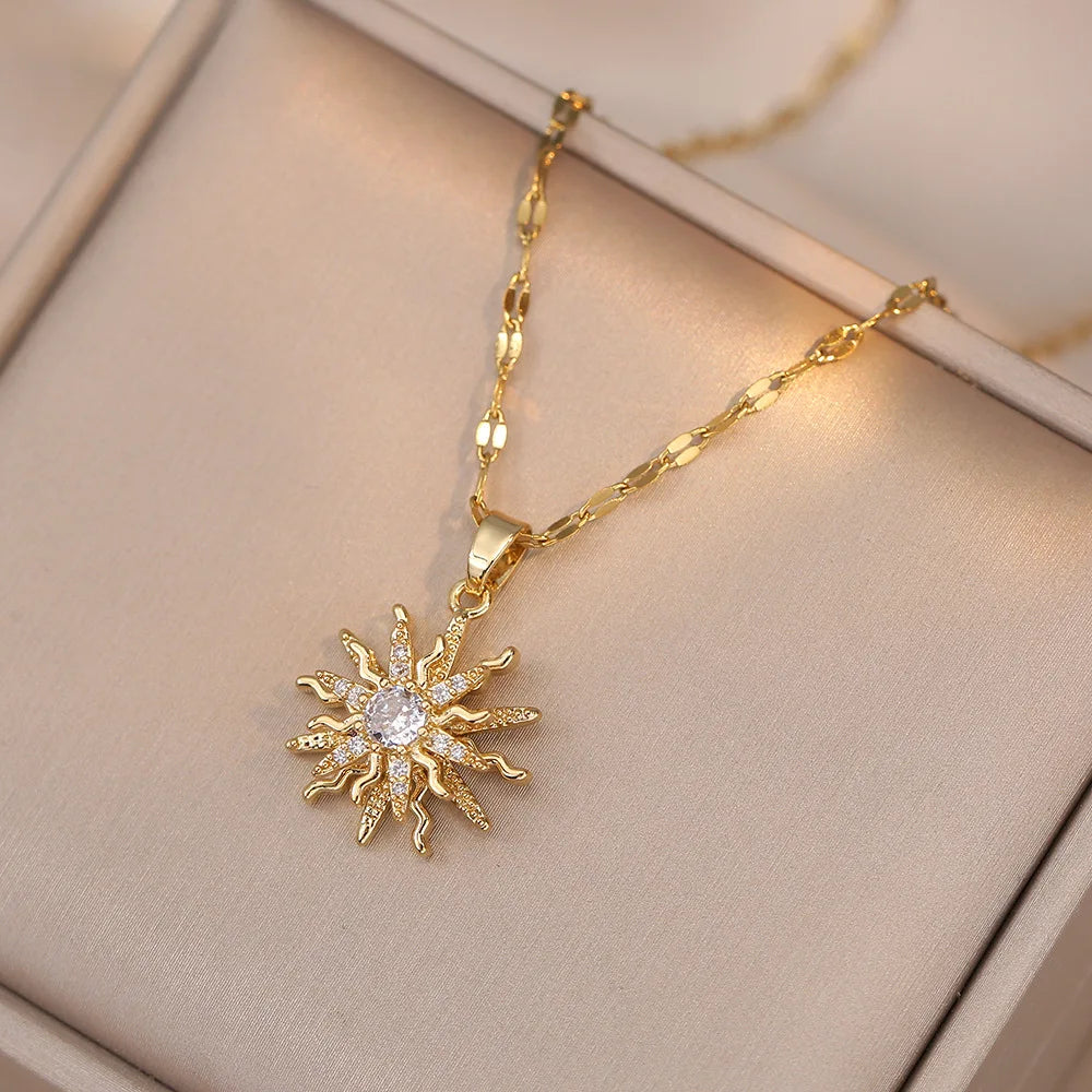 Romantic flat lay of gold pendant rose flower jewelry with roses and sunlight | Oria Jewel
