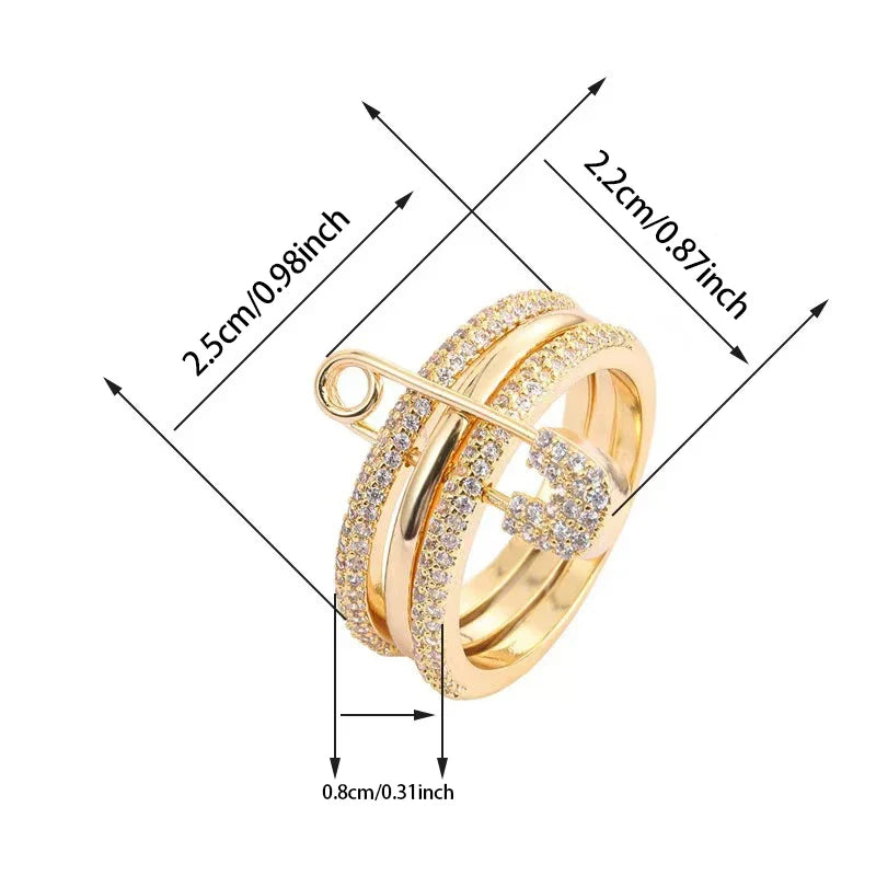 Gold Safety Pin Ring size graphic on white background with measurement arrows (2.5cm/0.98inch, 2.2cm/0.87inch, 0.8cm/0.31inch), pavé crystal bands with safety pin and heart charm | OriaJewel