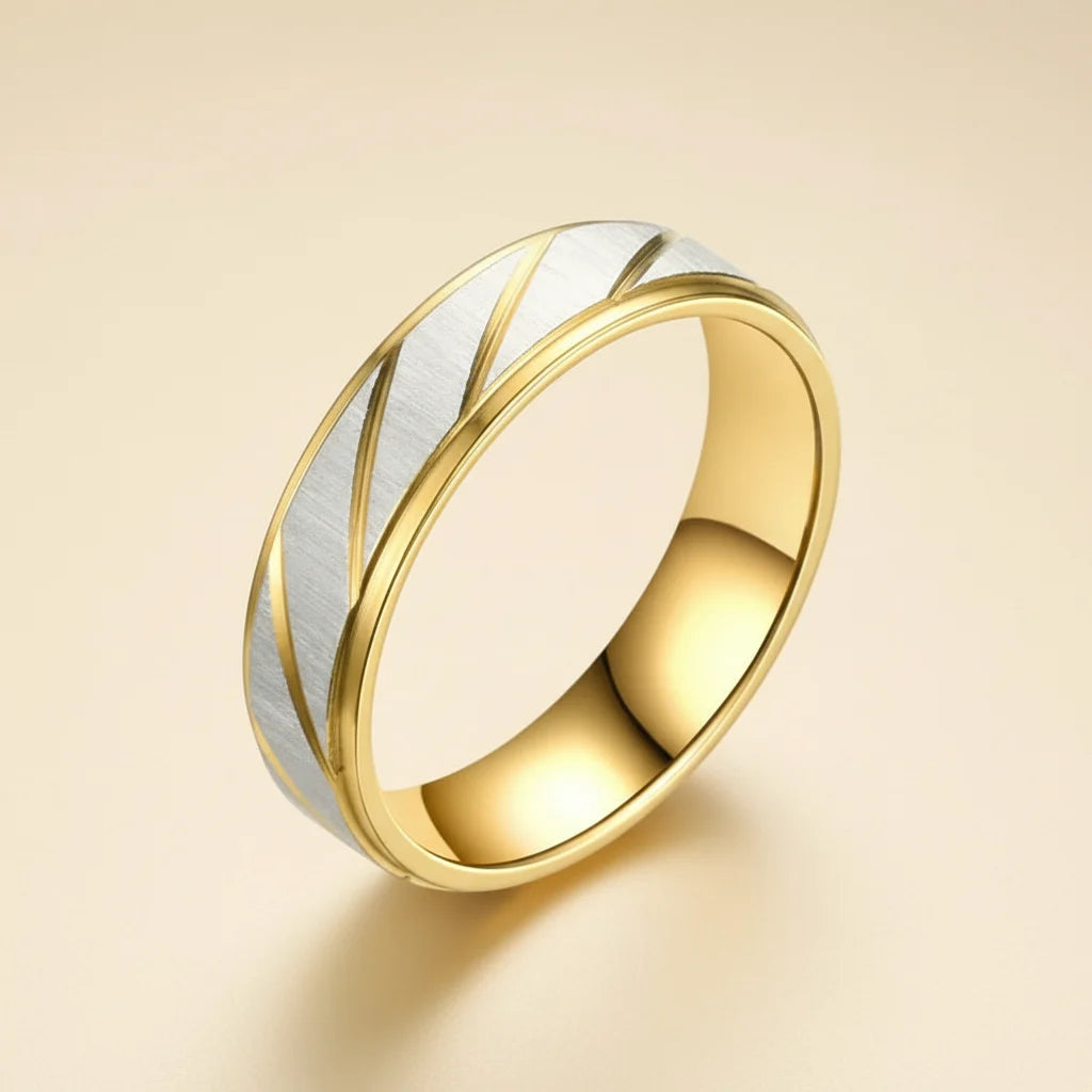 Close-up angled view of a Gold Silver Two Tone Band Ring with brushed silver center and diagonal gold grooves, polished gold edges, soft beige background | OriaJewel