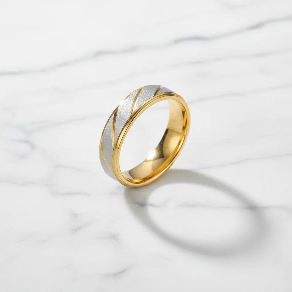Gold Silver Two Tone Band Ring on white marble surface with crisp soft shadow, brushed silver top with diagonal gold accents, premium minimal look | OriaJewel