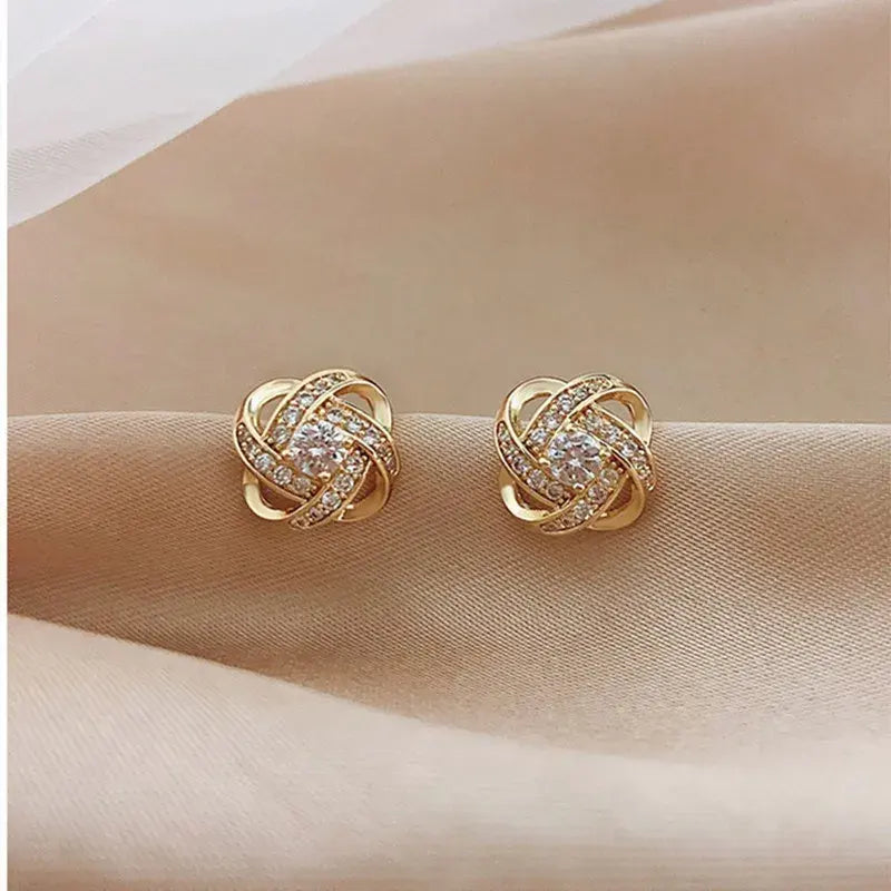 Gold Tone Knot Halo Stud Earrings close-up on satin fabric | OriaJewel