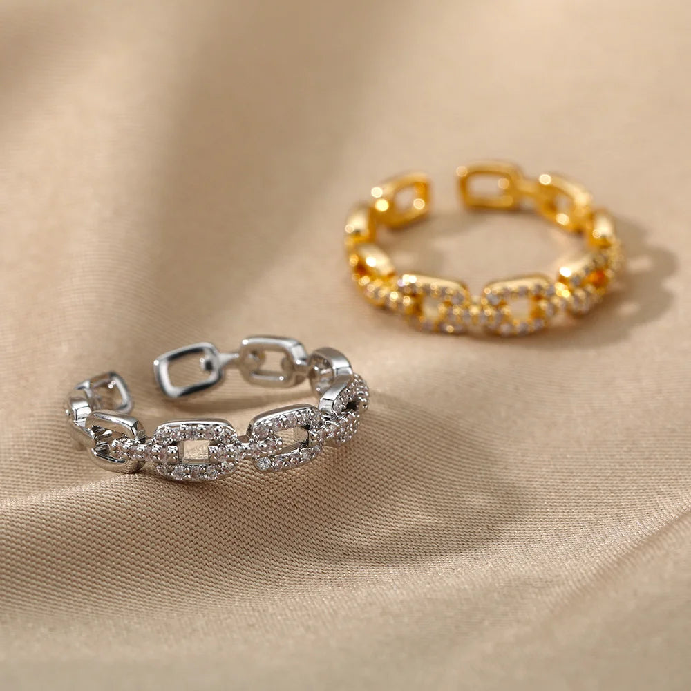 Silver Crystal Link Chain Ring in focus, gold ring blurred on textured fabric | Oria Jewel