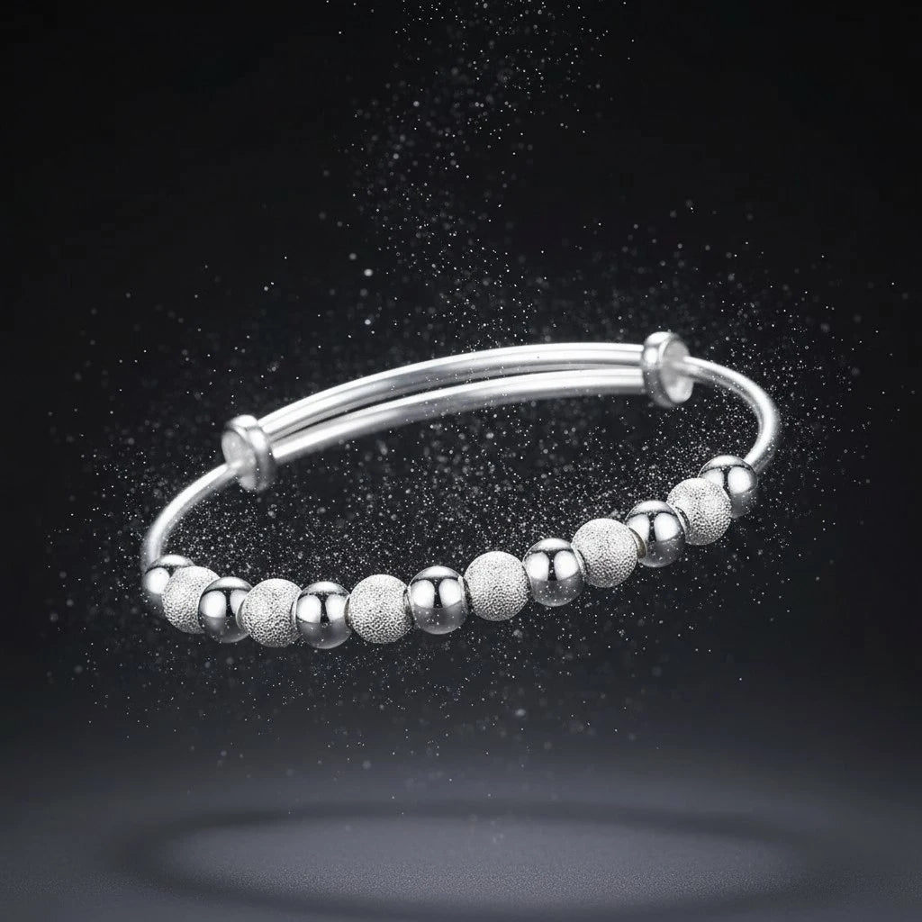 Dramatic shot of the Marvella Beaded Charm Cuff floating against a dark background with shimmering particles, emphasizing its celestial sparkle and modern bead design | Oria Jewel