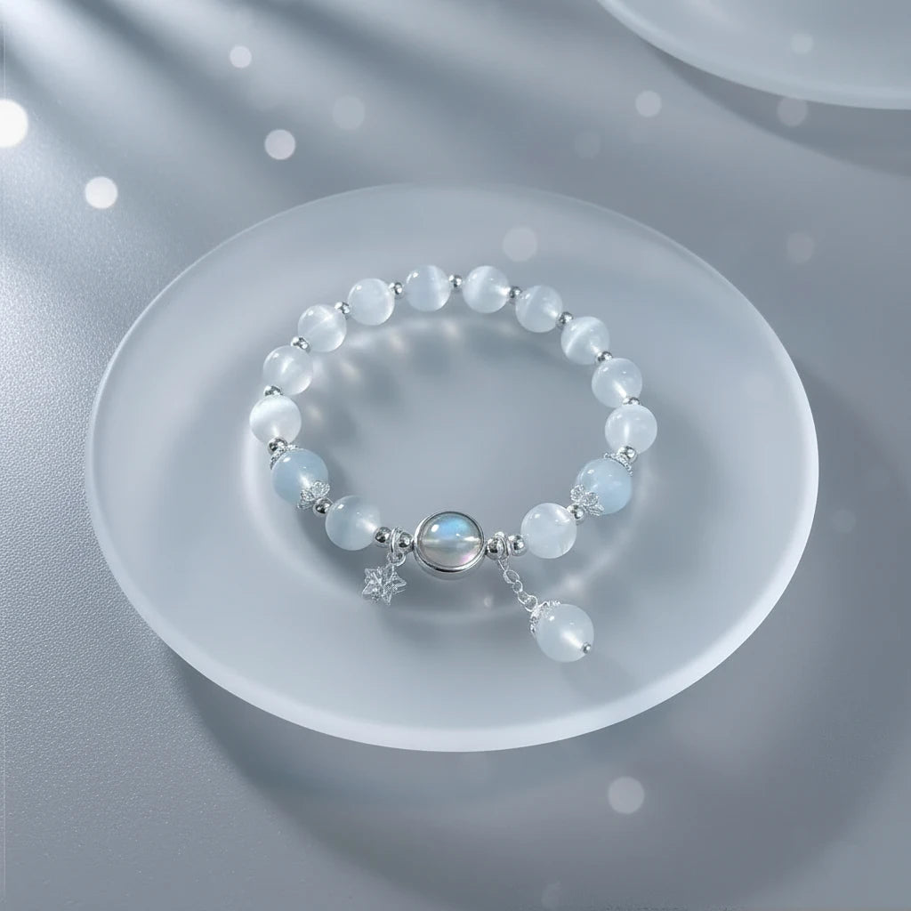 Close-up of Moonstone Glow Charm Bracelet arranged in a circle on a frosted glass plate, highlighting the luminous moonstone center and silver charms | Oria Jewel
