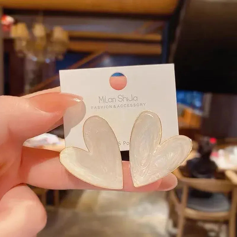 Pearl White Marble Heart Stud Earrings in-hand close-up on display card | OriaJewel