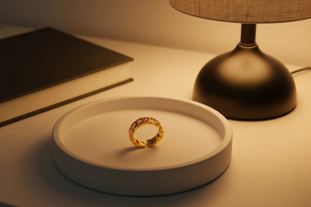 Rose stone band ring standing on a round tray under a warm table lamp, elegant nightstand setup | OriaJewel