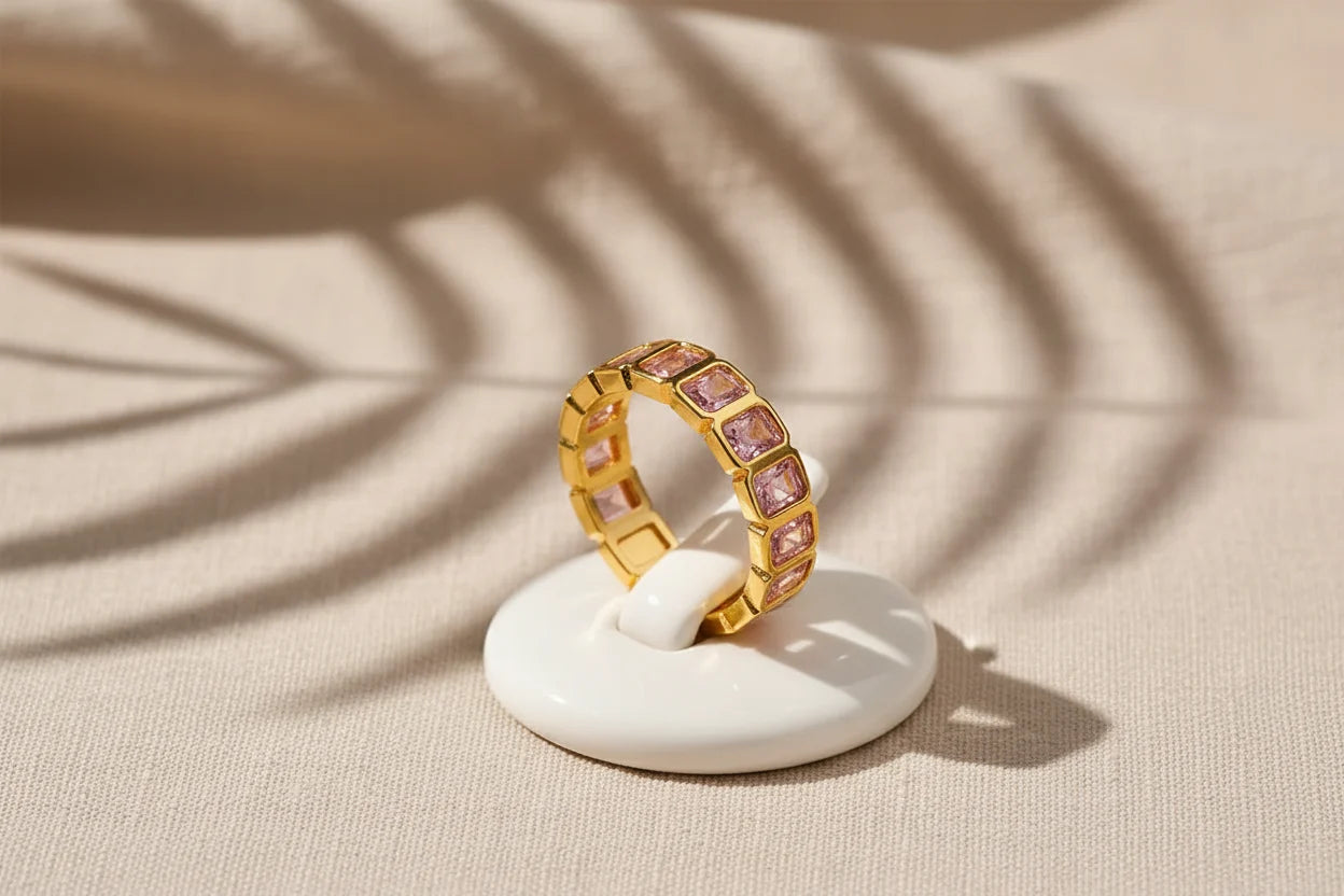 Rose stone band ring on a small white display stand with artistic shadow patterns on textured fabric | OriaJewel