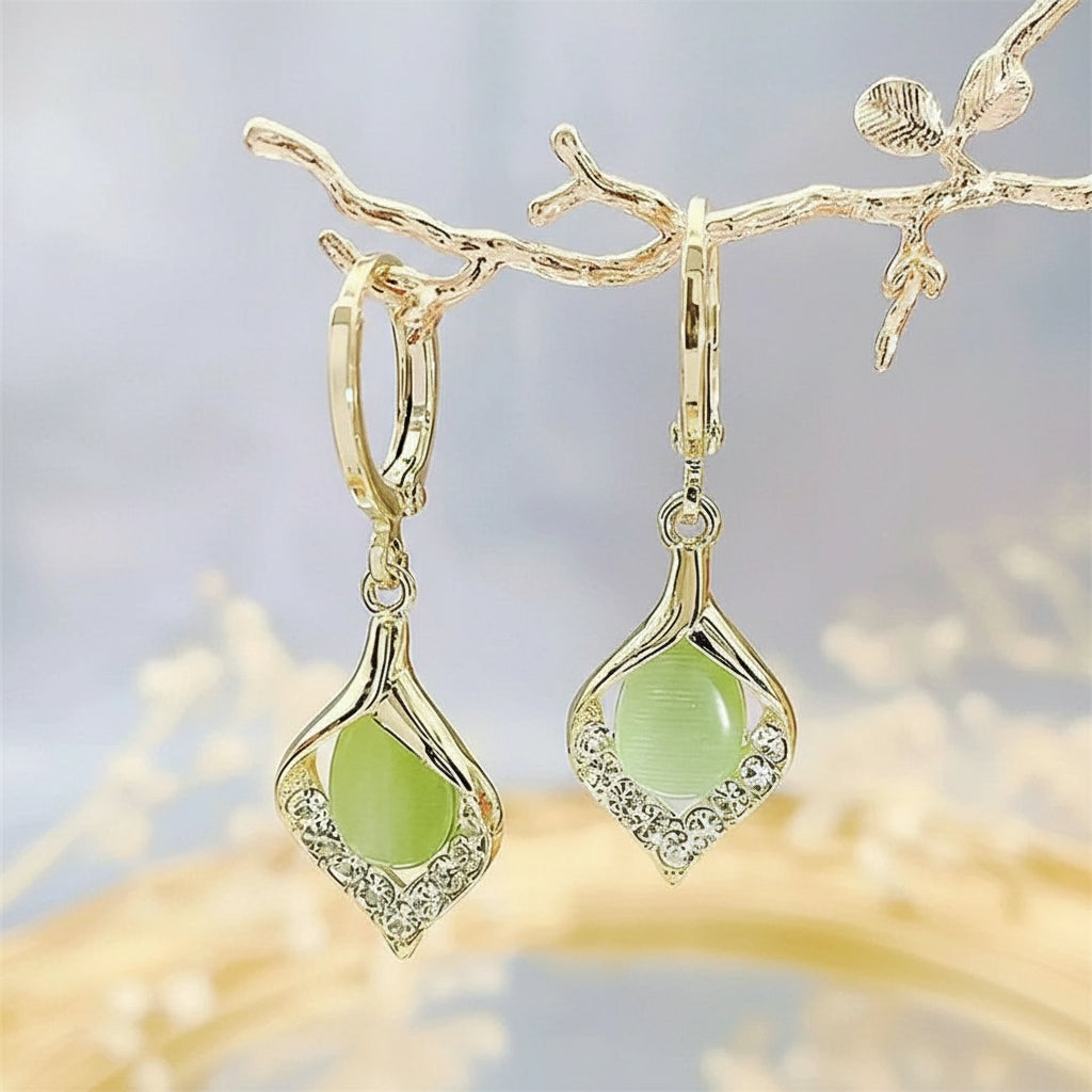 Gold elegant teardrop earrings with shimmering green gems and crystals on a branch | Oria Jewel