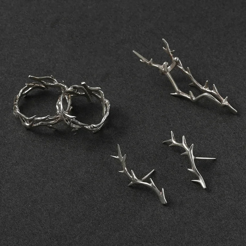 Bright sterling silver vine rings, earrings, and a cuff on a dark surface | Oria Jewel