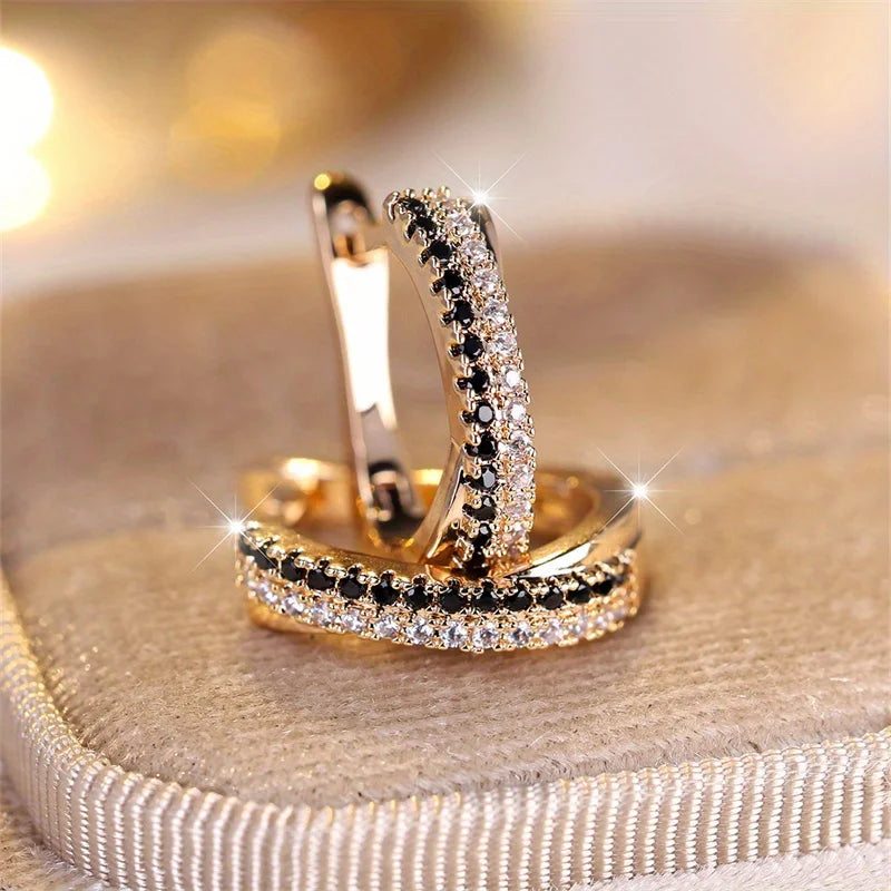 Two gold crystal hoop earrings with black and white stones sparkle on velvet | Oria Jewel