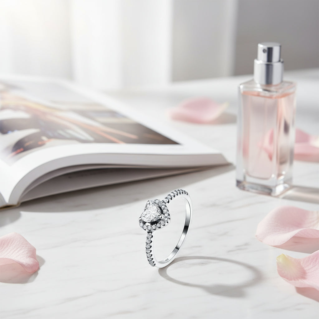 Ruby Heart Promise Ring displayed beautifully next to a perfume bottle and a magazine, surrounded by rose petals | Oria Jewel