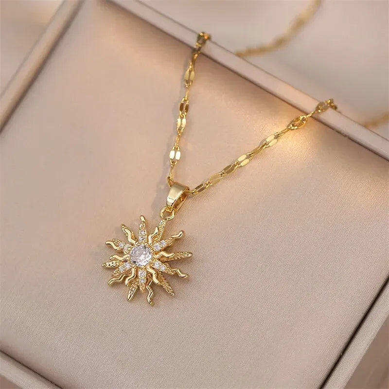 Romantic flat lay of gold pendant rose flower jewelry with roses and sunlight | Oria Jewel