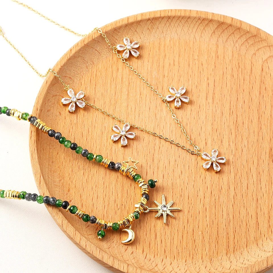 close-up of gold layered star necklace glowing under soft warm light | Oria Jewel