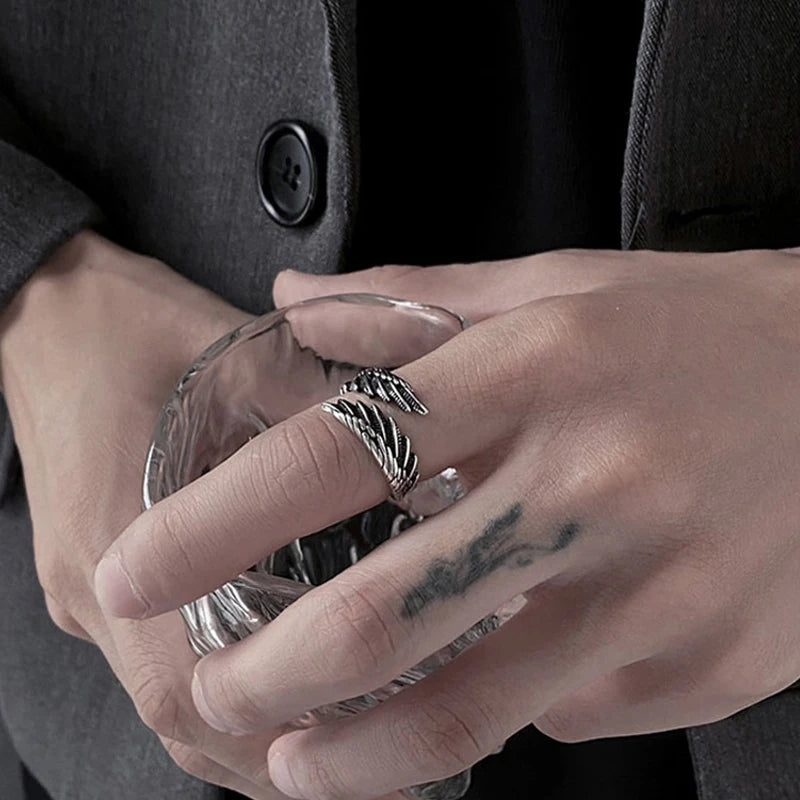 Close-up of a hand wearing an Angel Bat Wrap Ring while holding a glass | Oria Jewel