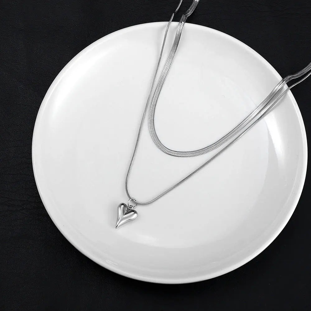 Elegant close-up of silver heart pendant layered necklace | Oria Jewel