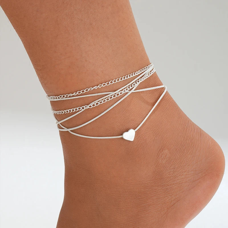 Beach-style shot of Bohemian Starfish Anklet Set stacked with sandals and shells | Oria Jewel