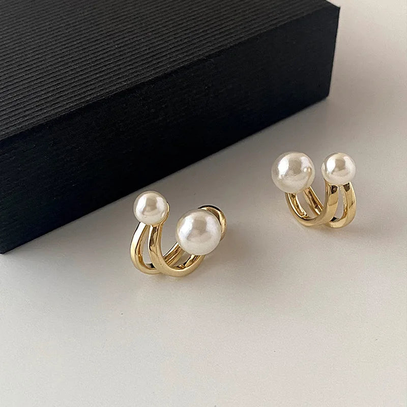 Shining gold freshwater pearl stud earrings displayed against a white surface and black box | Oria Jewel