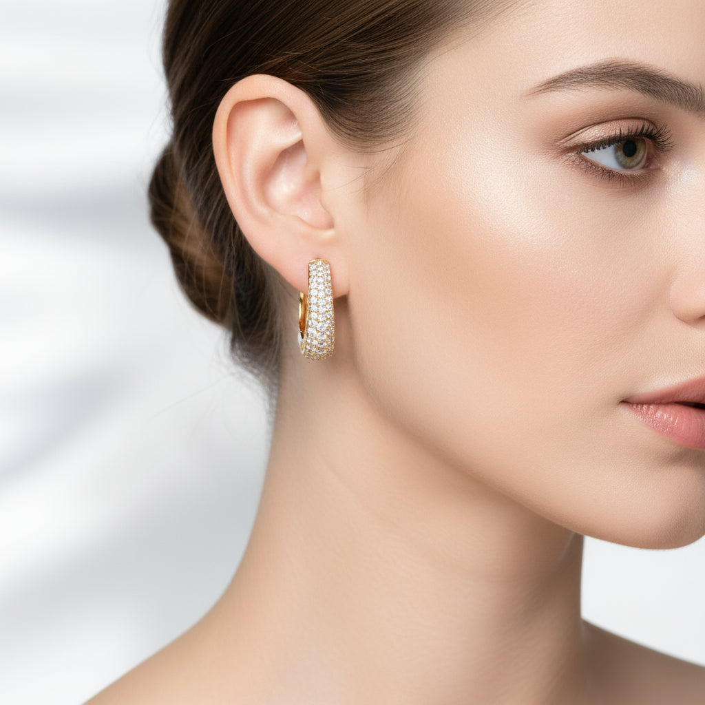 Close-up of Crystal Gold Huggie Earrings on a woman&