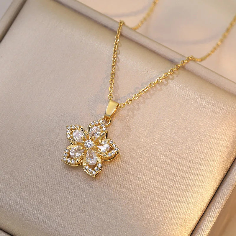 Romantic flat lay of gold pendant rose flower jewelry with roses and sunlight | Oria Jewel