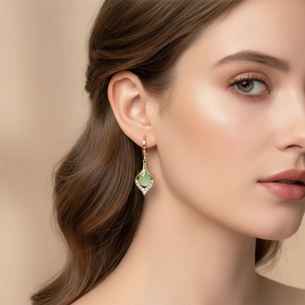 Woman models elegant teardrop earrings: gold-toned setting, light green gemstone, sparkling crystals | Oria Jewel