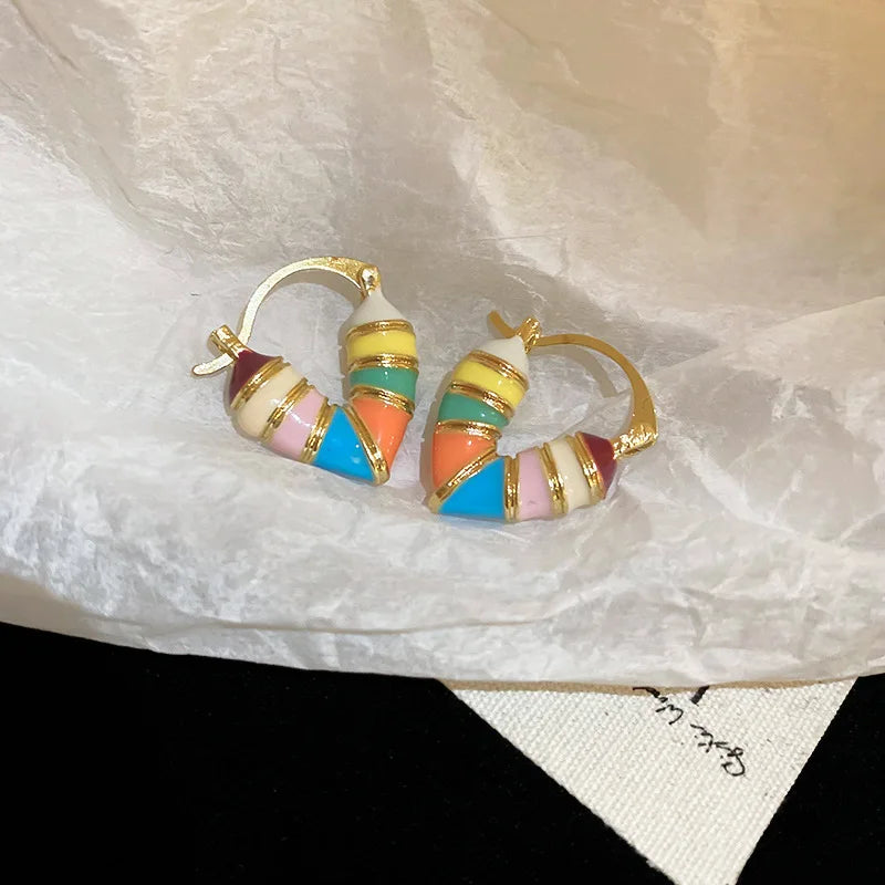 Gold-toned Colorful Enamel Hoop Earrings brightly lit on wrinkled white paper | Oria Jewel
