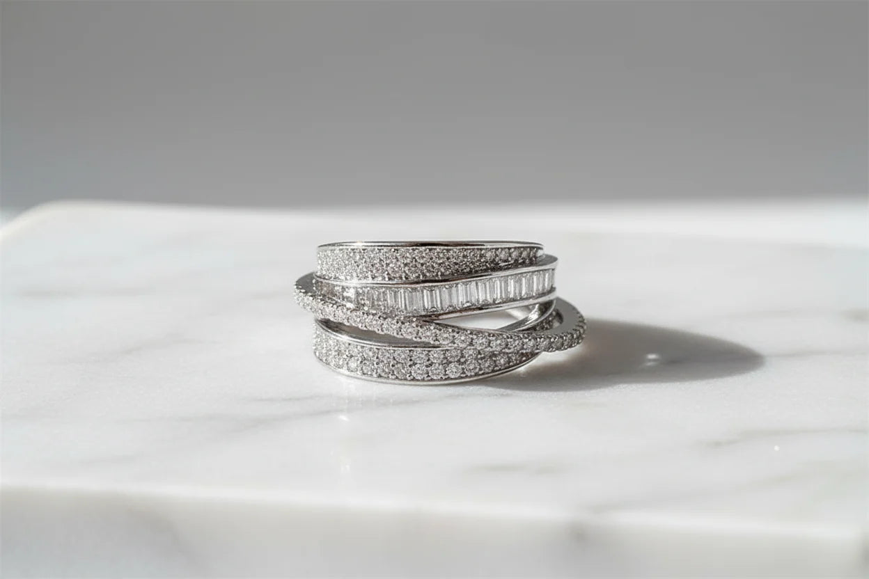 Silver CZ Wrap Ring on white marble in bright sunlight, clean shadowing that highlights the multi-band wrap layers and the sparkle of the CZ stones | OriaJewel