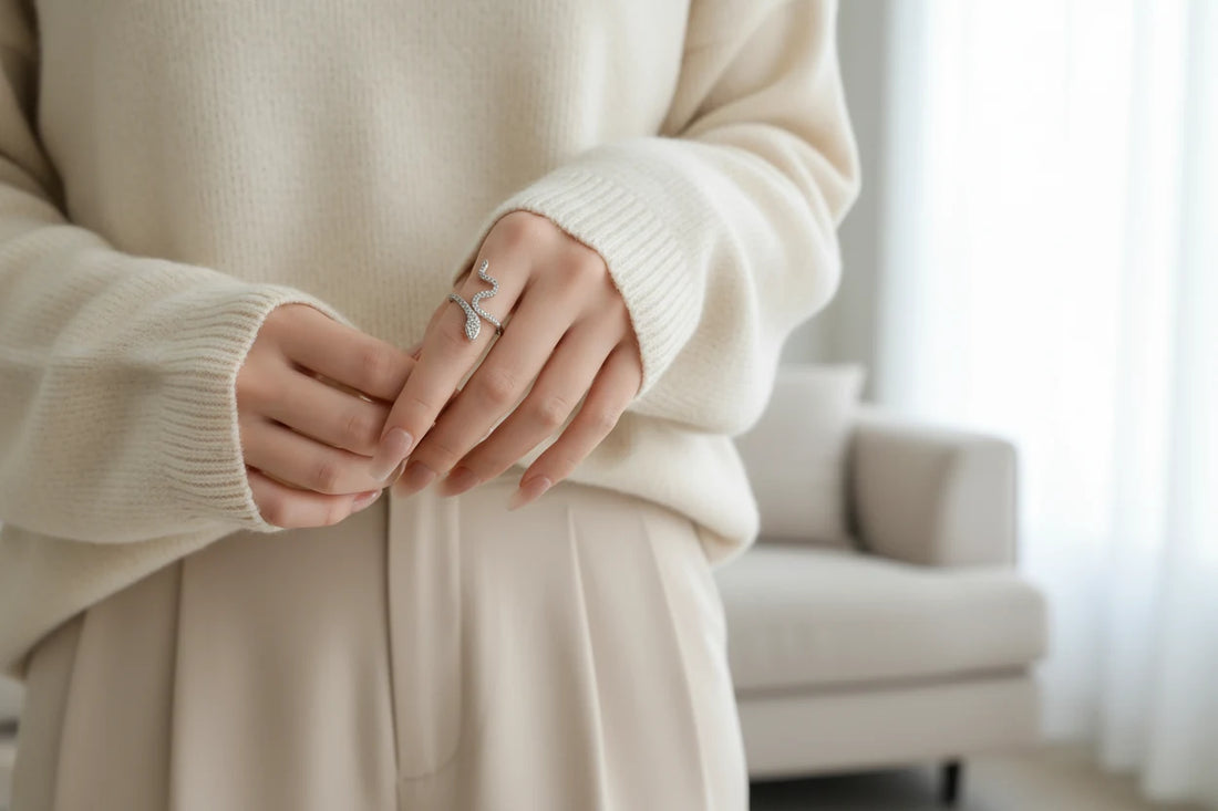 Silver Pavé Snake Wrap Ring worn on a hand with a cozy cream knit sweater, soft daylight lifestyle shot highlighting the sparkling snake silhouette on the finger in a minimal home setting | OriaJewel