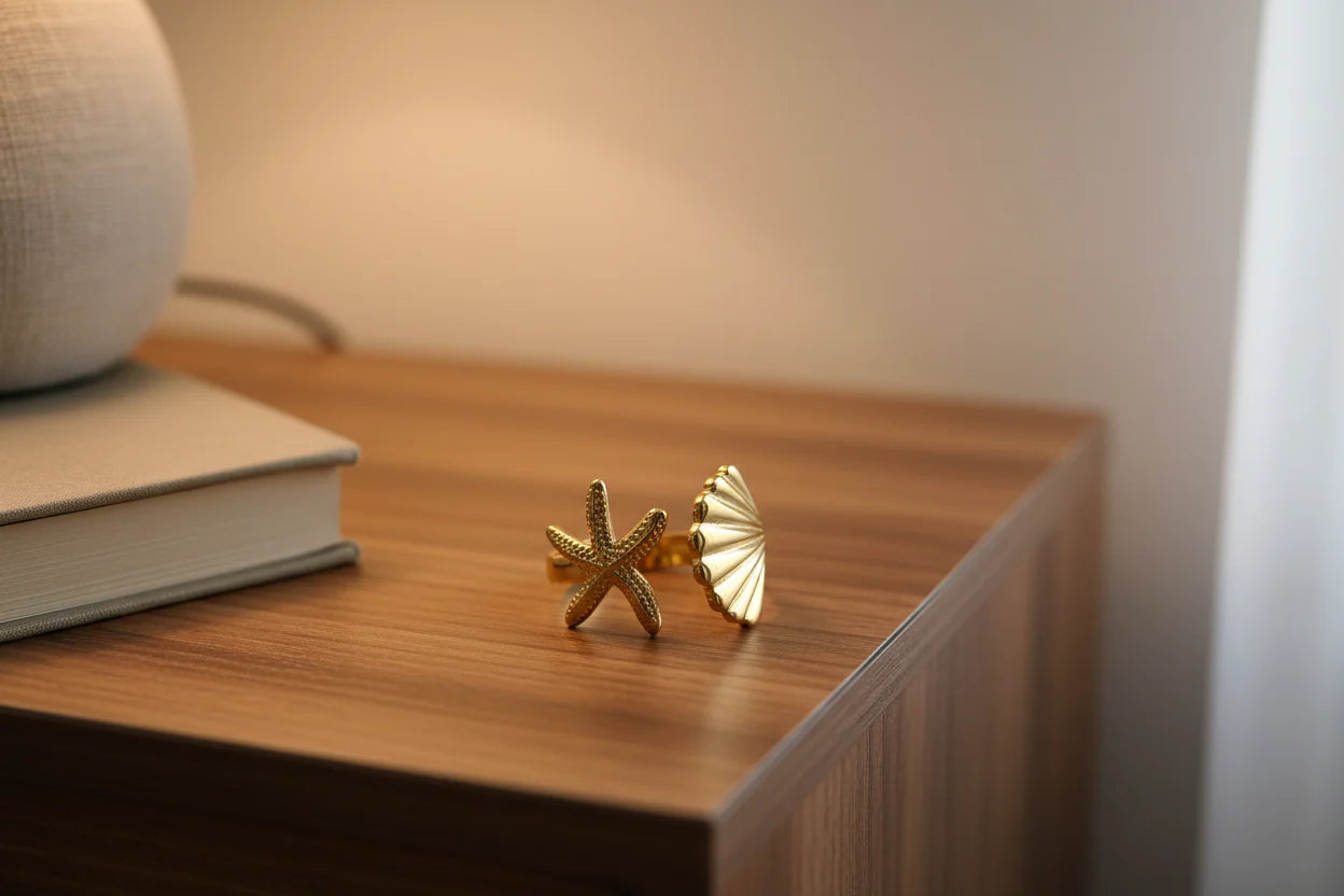 Starfish Gold Ring displayed on a wooden bedside table near a book and lamp, cozy warm lighting highlighting the ocean-inspired details | OriaJewel