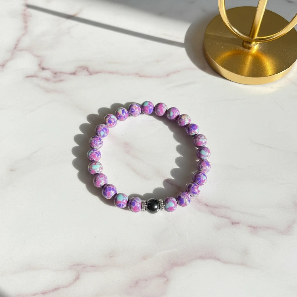 Stress Relief Gemstone Bracelet resting on a sunlit marble surface beside a golden jewelry stand for a luxury feel | Oria Jewel
