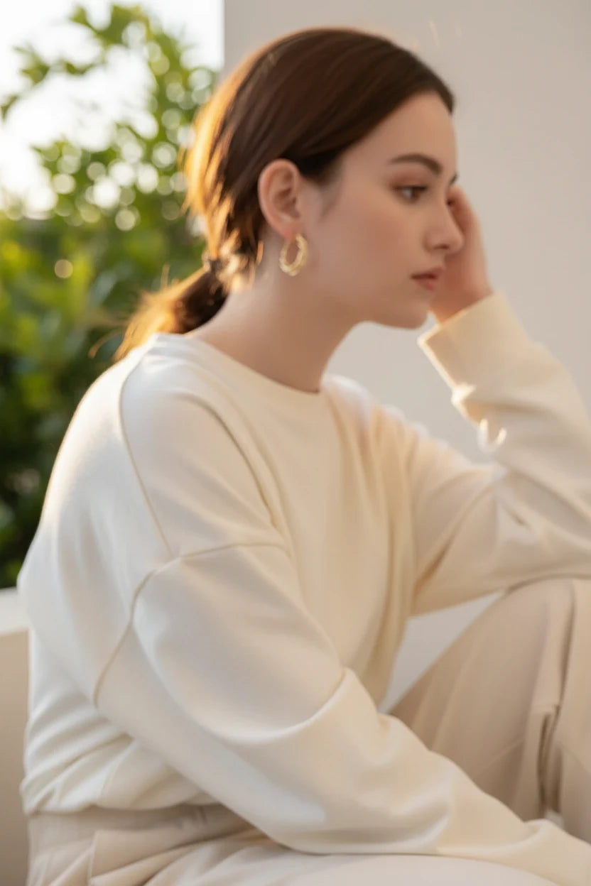 Twisted Crossover Hoop Earrings worn on model in soft sunlight | OriaJewel