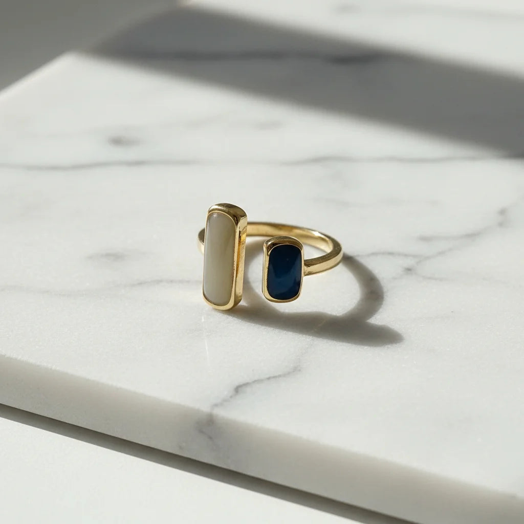 Two Stone Open Ring close-up on a white marble surface in bright natural light, crisp shadow and shine, showing ivory and deep blue rectangular stones | OriaJewel