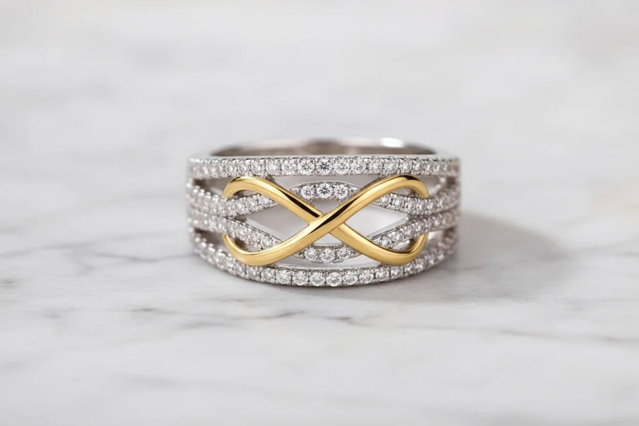 Two Tone Criss Cross Ring front-on product shot on a soft white surface, crisp focus on the intertwined gold ribbon design and shimmering pavé rows across the wide band | OriaJewel