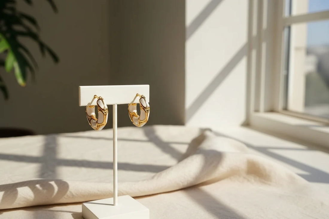 White Huggie Hoop Earrings on display stand in sunlight by the window | OriaJewel