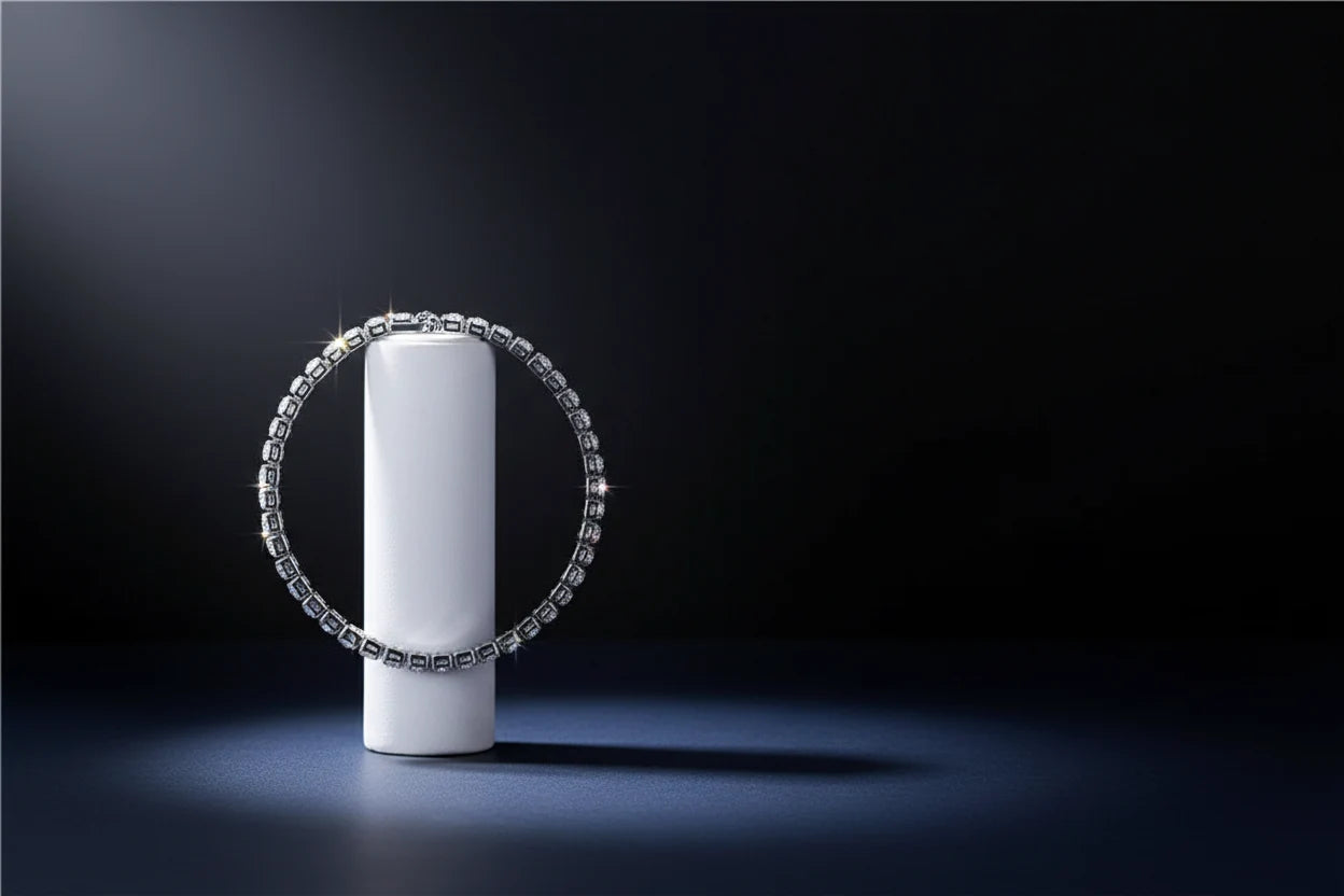 Dramatic studio shot of a cz tennis bracelet standing upright around a white cylinder pedestal against a deep black background, stones sparkling under a focused spotlight for an elevated, luxurious feel | Oria Jewel