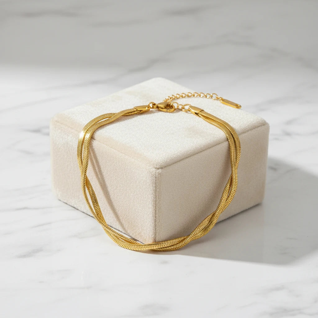 Gift-ready double chain gold bracelet displayed on a soft beige velvet jewelry box set on white marble with gentle natural light and shadows | Oria Jewel