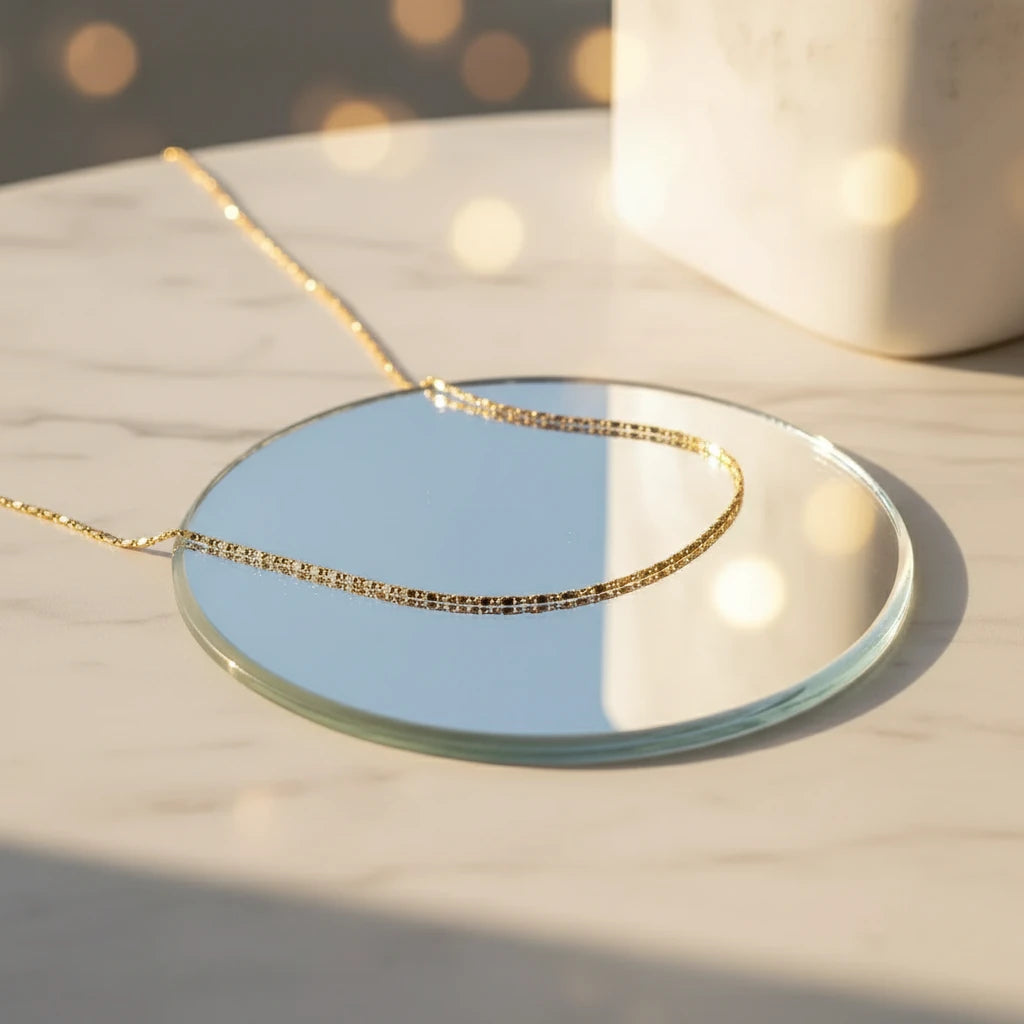 Flat Chain Choker displayed on round mirror under soft golden light — modern luxury design | Oria Jewel
