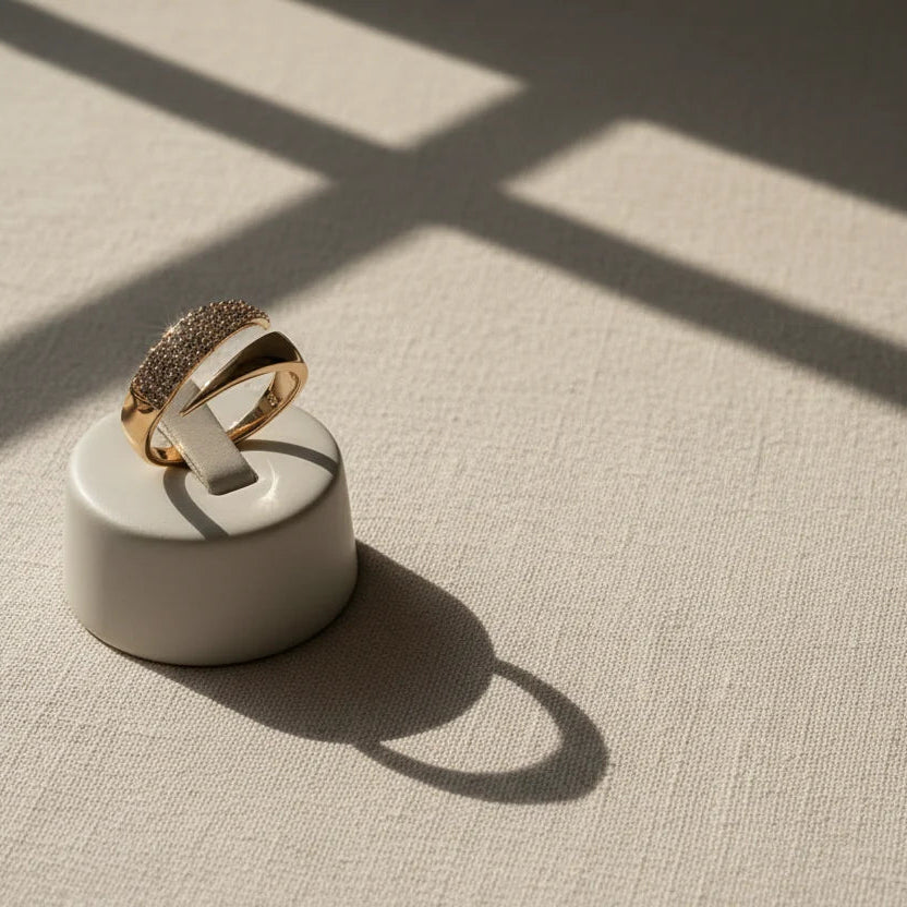 Studio display with window-shadow pattern, showing a gold bypass ring on a white stand to highlight the crossover silhouette | OriaJewel
